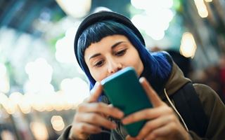 Person som stirrar på en smarttelefon utomhus