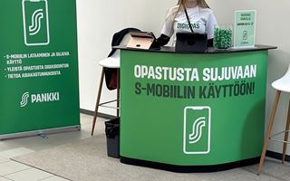 En informationsdisk med texter om mobilanvändning, omgiven av gröna dekorationer och broschyrer.